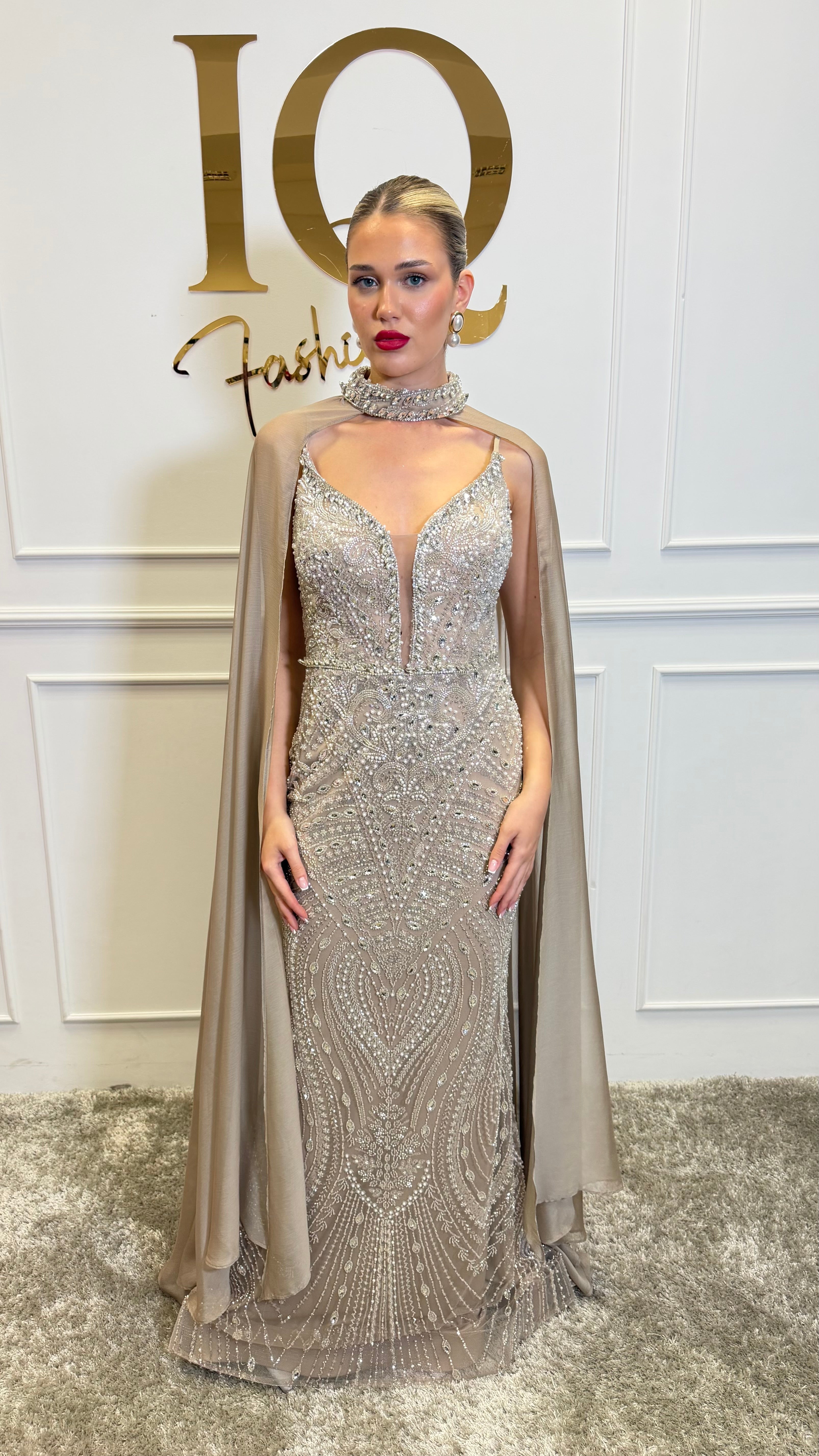 Rochie cu pelerină Indiana beige de la iqfashioncluj, cu croială elegantă și detalii stilate, pe fundal neutru.