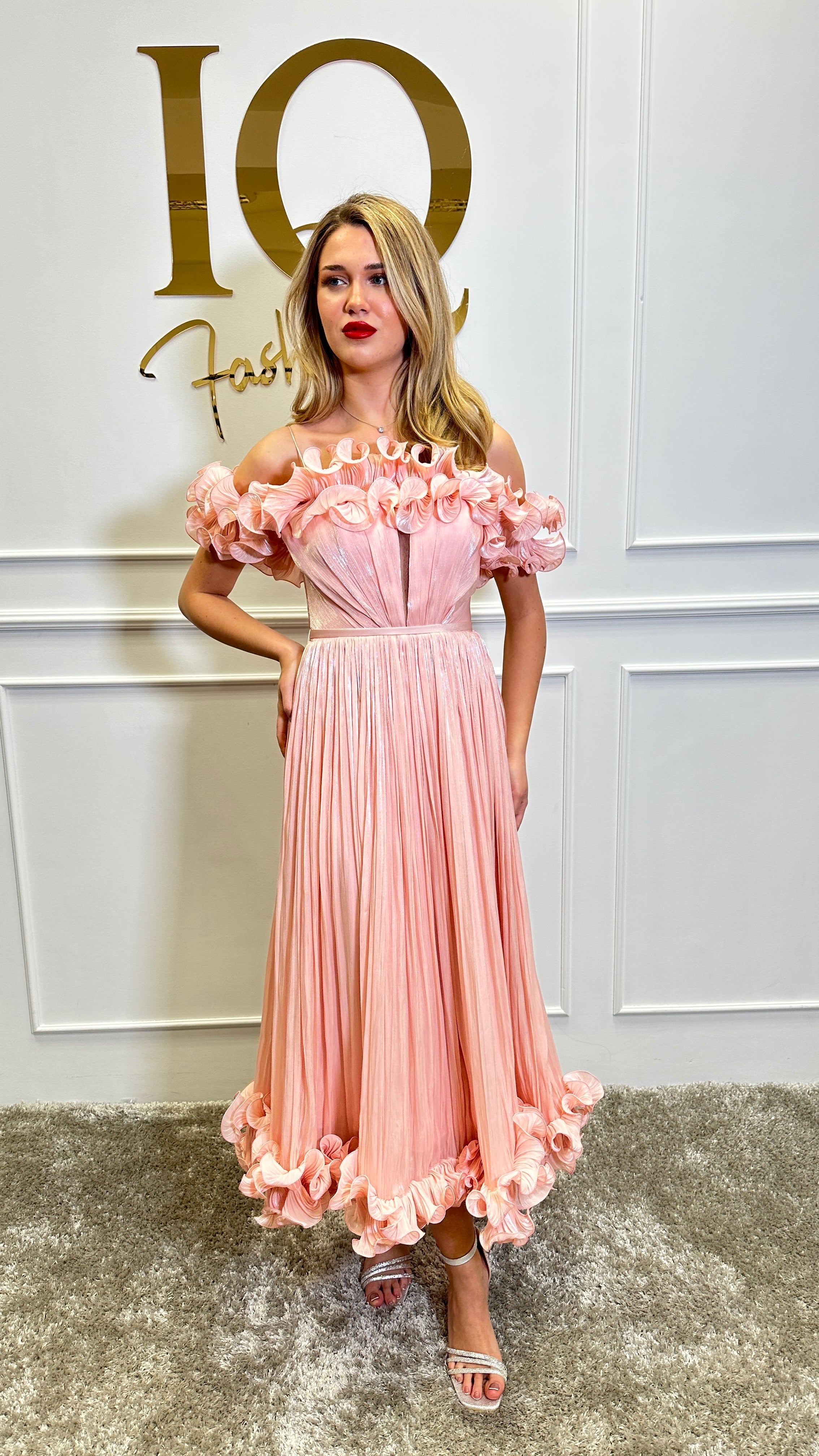 Pink Rochie Cassilia from iqfashioncluj with elegant design, shown hanging on a hanger with floral background.