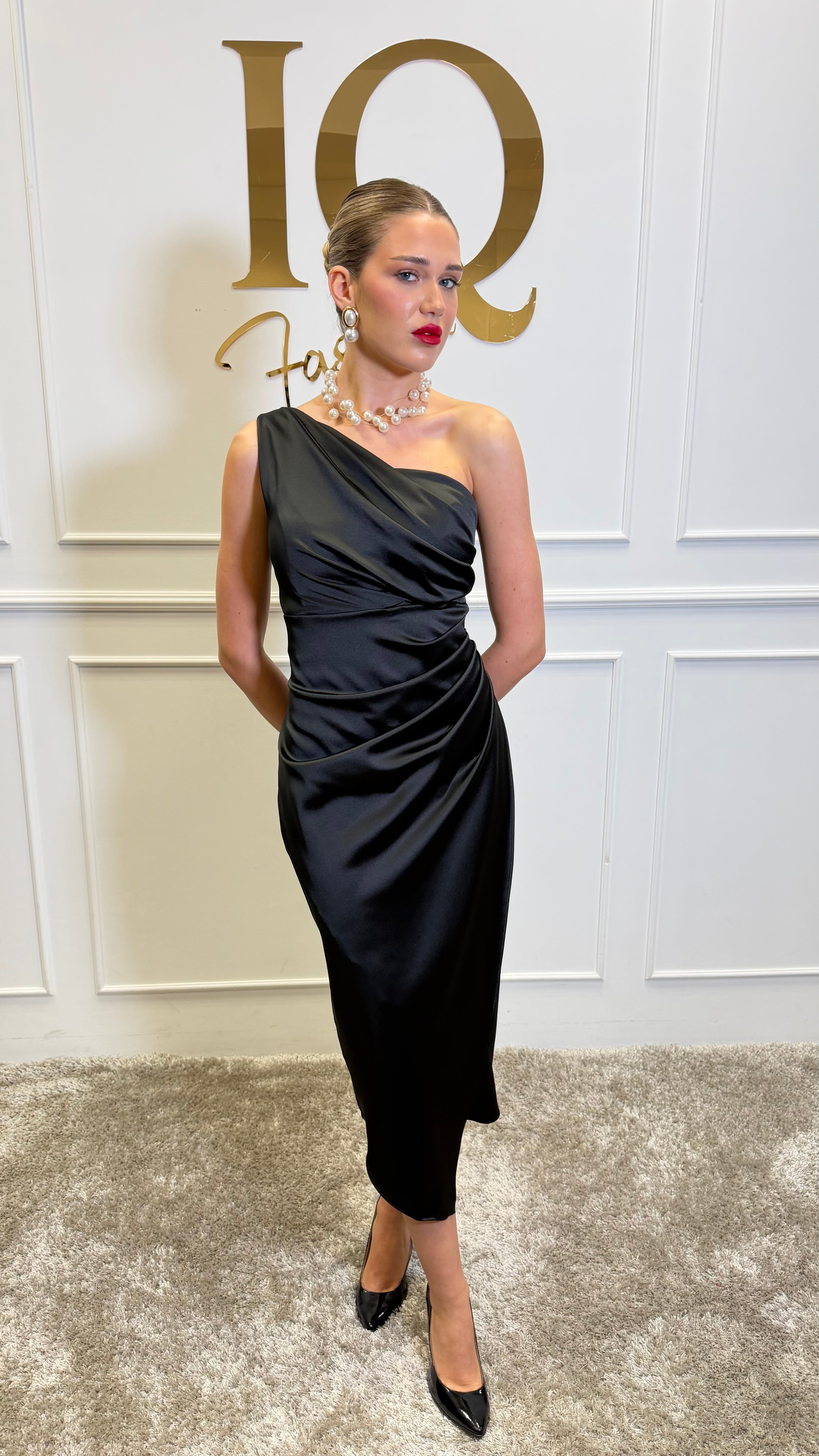 Rochie midi neagră Simone de la iqfashioncluj, detalii elegante și croială modernă, pe manechin sau purtând-o într-un decor stilat.