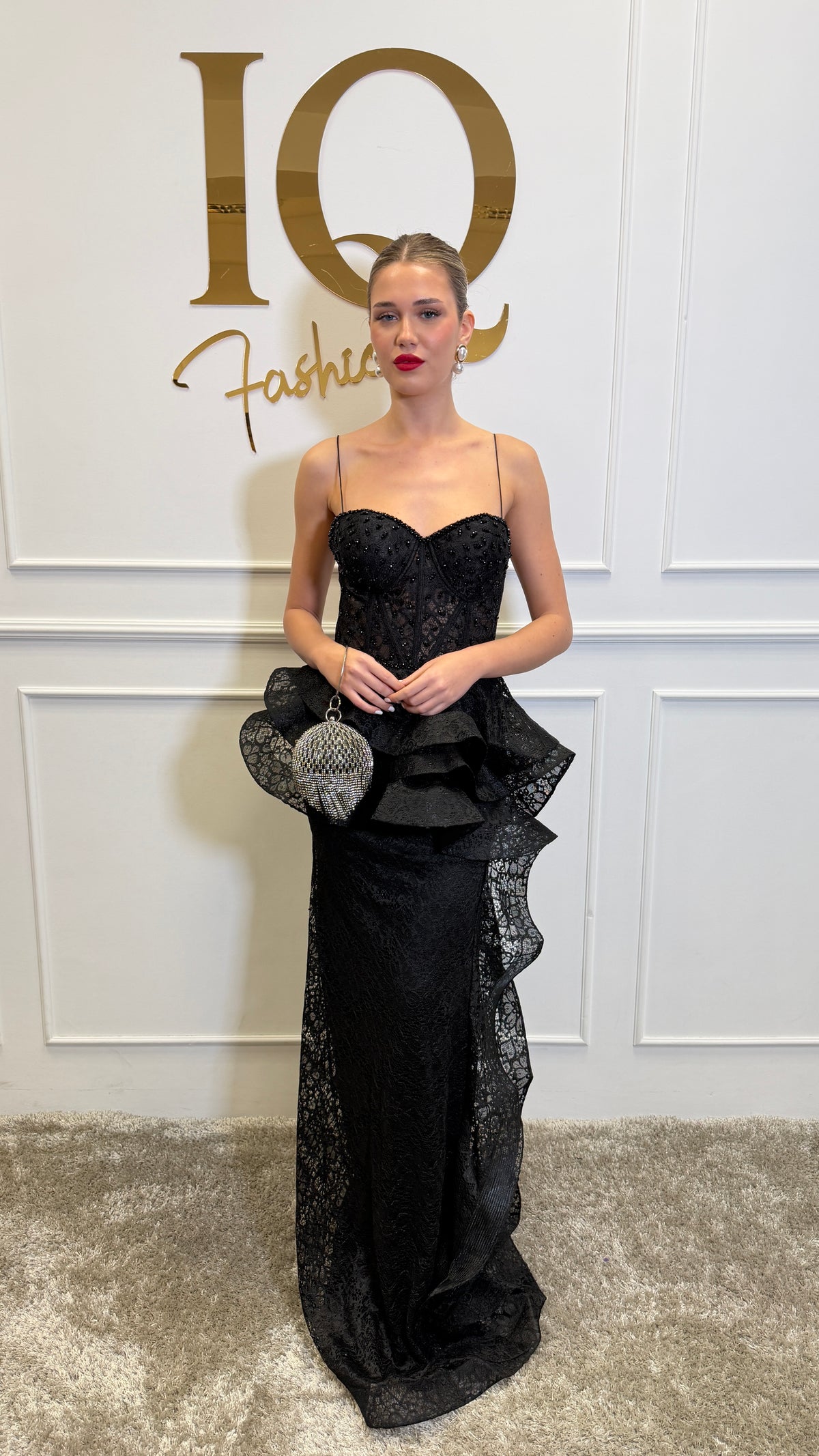Rochie neagră Almelya de la iqfashioncluj, cu croială elegantă și detalii moderne, pe model purtând-o într-un decor minimalist.