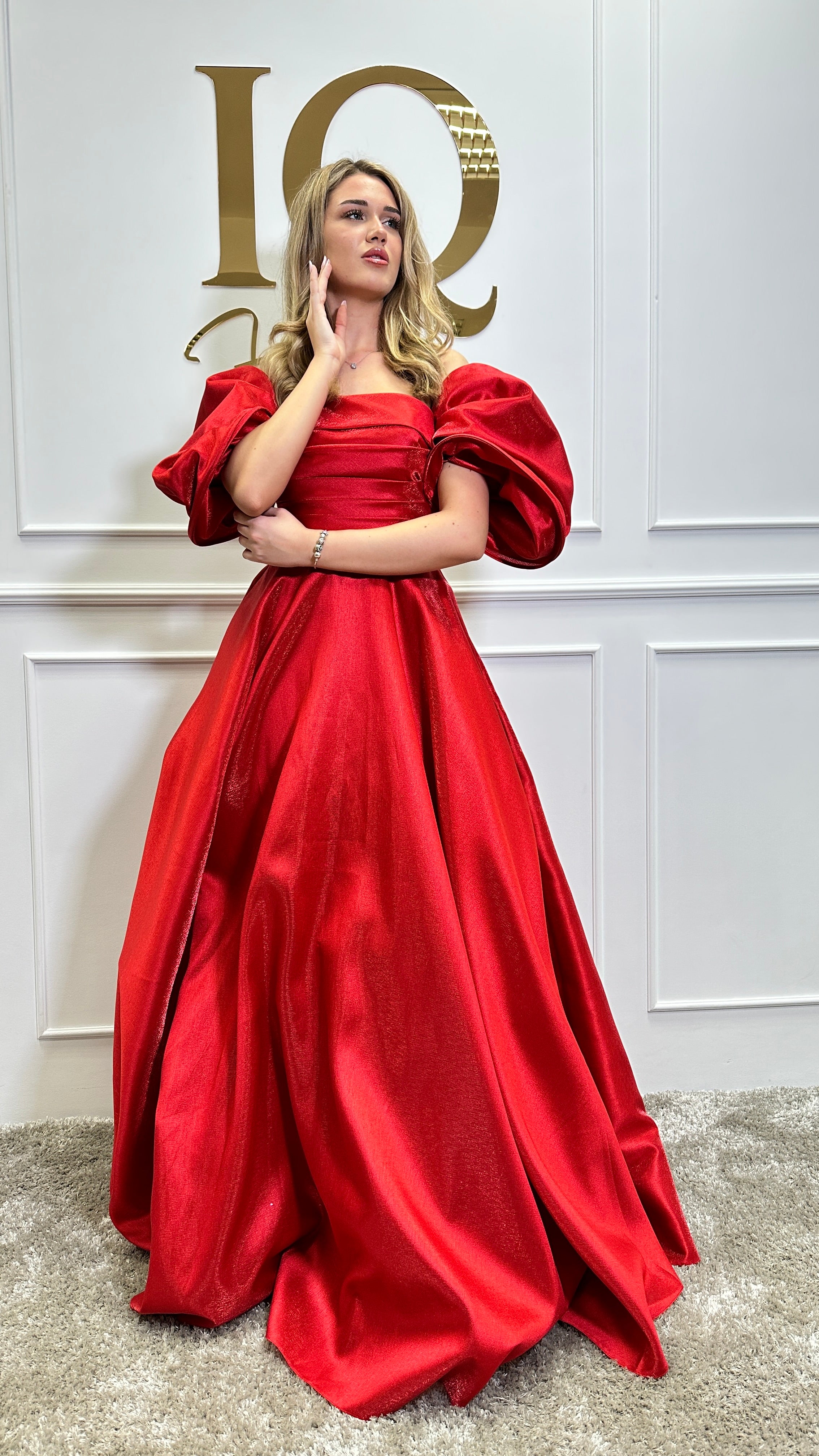 Rochie roșie Sassya de la iqfashioncluj, elegantă, cu croială modernă, afișată pe manechin într-un decor minimalist.