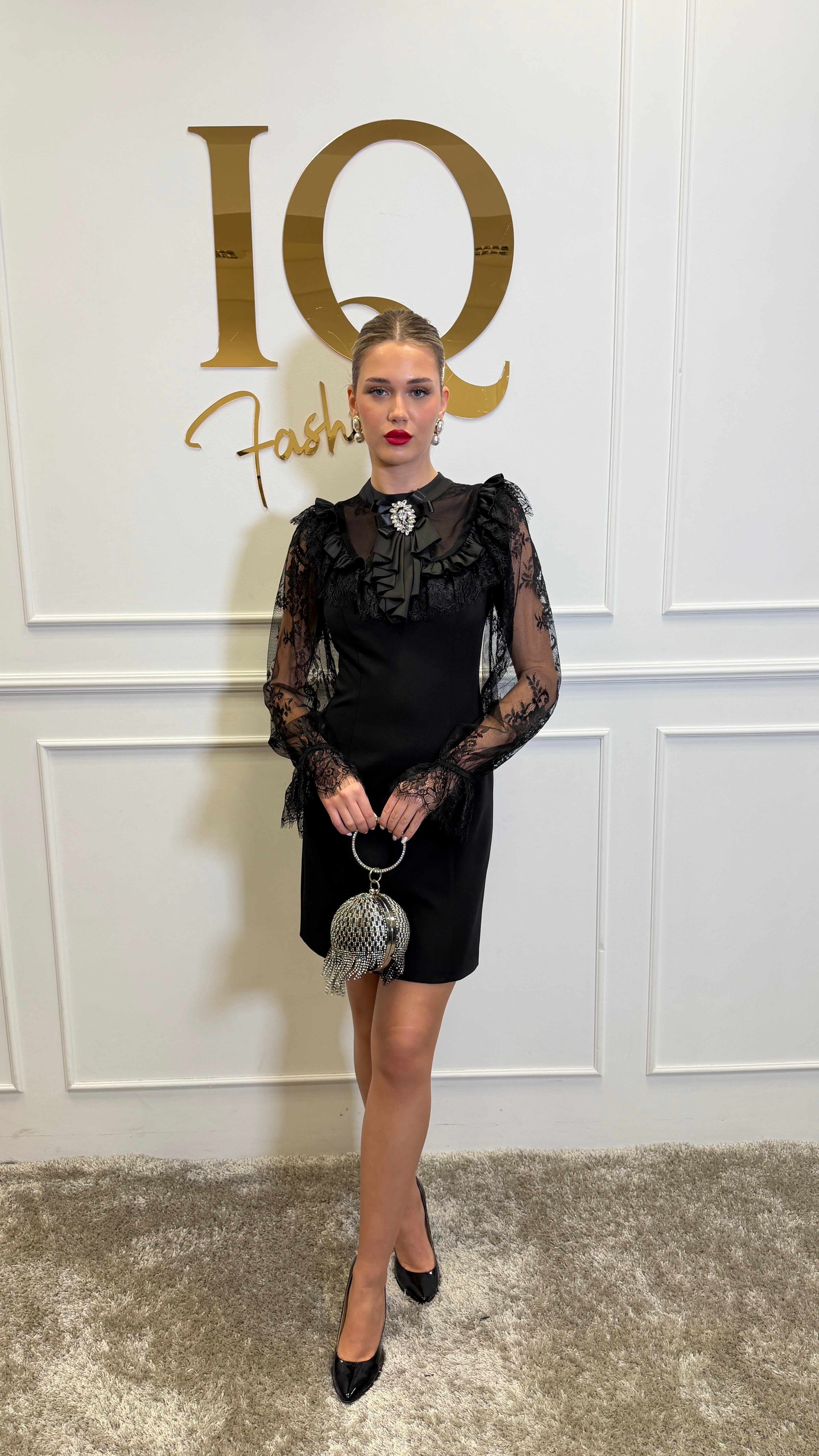 Rochie de damă din dantelă neagră Madona Black, cu mâneci lungi, de la iqfashioncluj, vizibilă în imagine.